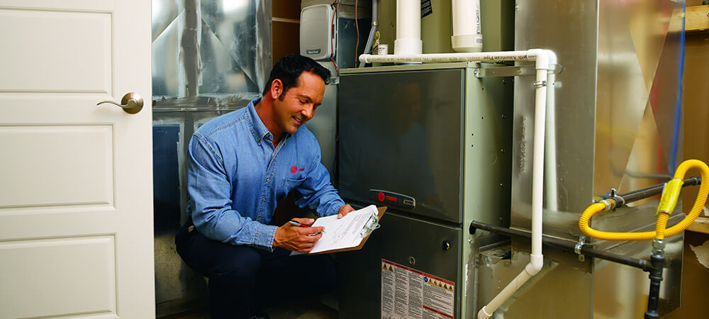 hvac tech inspecting heating unit
